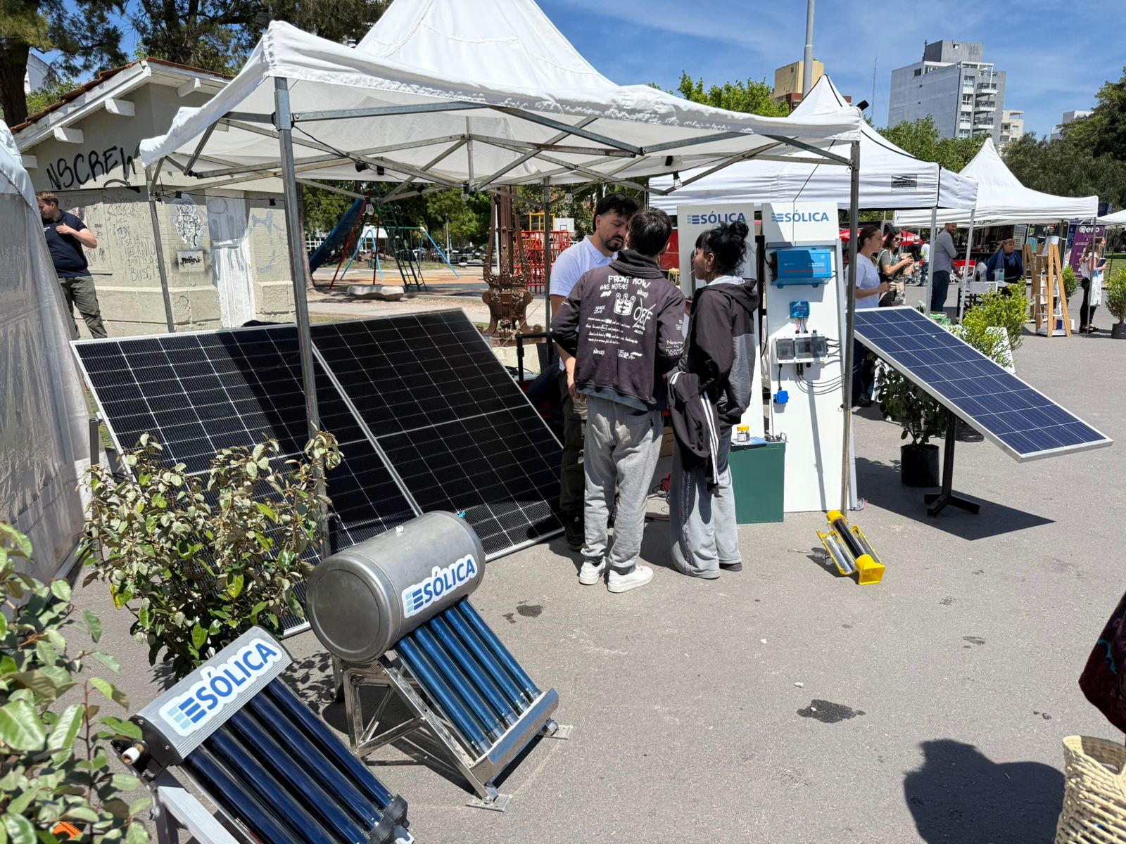 Tienda con paneles solares y calefones en una feria de energía renovable.